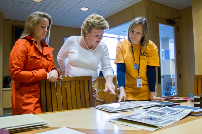 Suzanne Carlisle Vick, center, and her daughter Rachel, left, learn about Hugh Toland's history from UCSF Archivist Polina Ilieva.