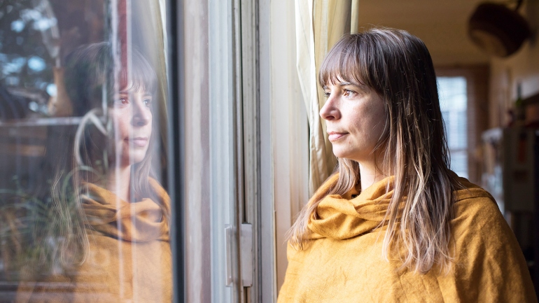 Eve Ekman looks out the window of her San Francisco home