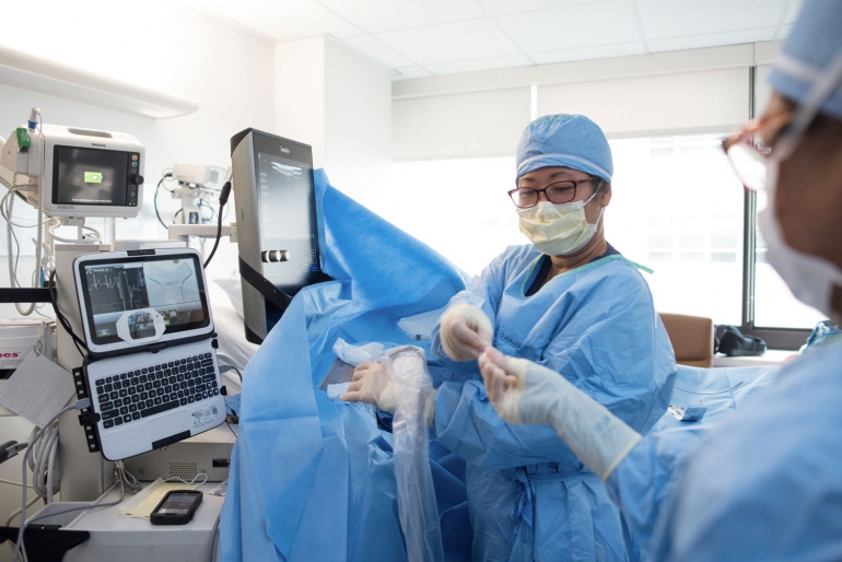 clinicians doing a procedure in a hospital room