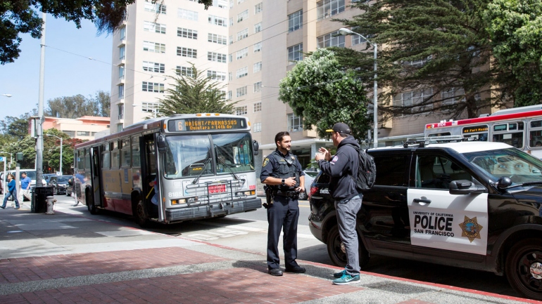 UCSF police officer talks to a man on the Parnassus campus