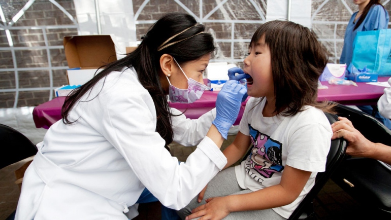 A UCSF dental resident gives dental screening to a child