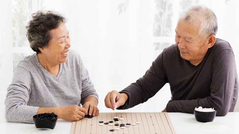 Elder couple playing a board game. 