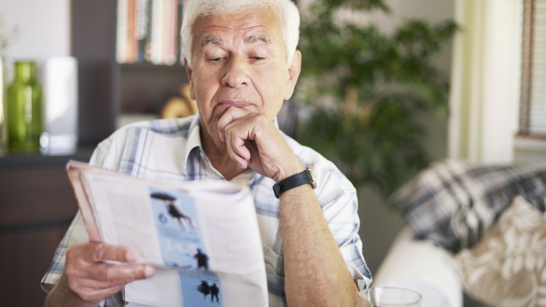 stock image of elderly man reading a magazine