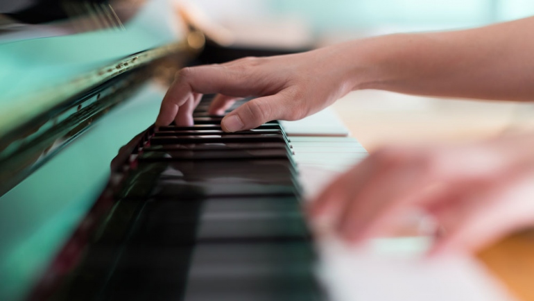 stock image of hands playing a piano