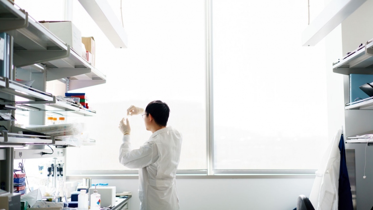 UCSF researcher examines a sample at the window of his lab