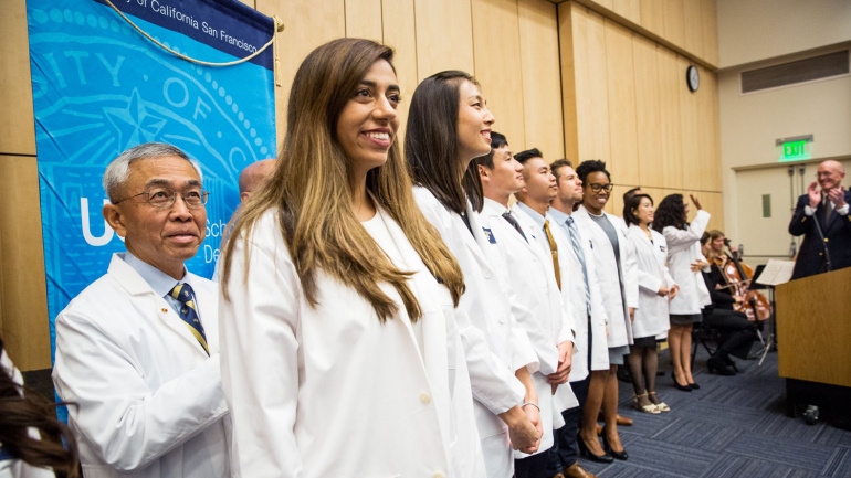 UCSF dental students line up on stage during their white coat ceremony