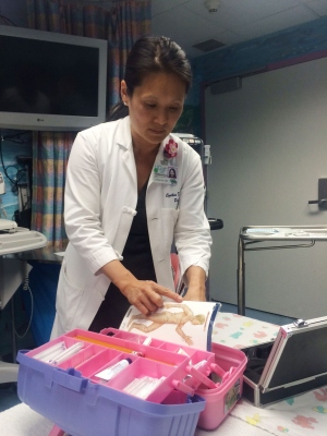 Dr. Cynthia Kim opens her pink acupuncture tool box