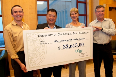 Paul Takayama, director of Community and Government Relations at UCSF,  center, presents the University's donation to the SF Parks Alliance's Blue Green-  way project. Since 2010, UCSF has donated more than $65,000 to the project with  proceeds from San Francisco Giants' game parking fees.