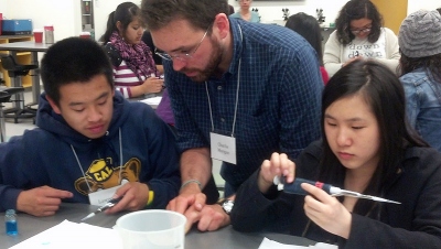 SEP scientist volunteer Charlie Morgan teaches High School Interns Lawrence  Lee, 17, and Laura Wu, 16, pipetting skills.