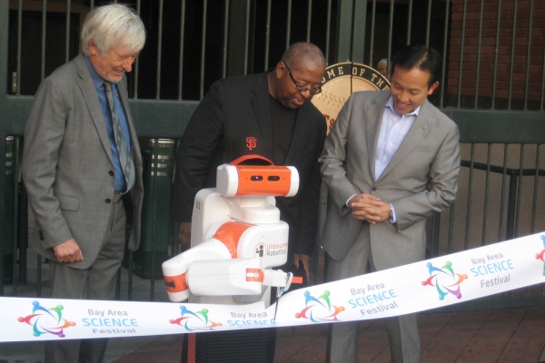 UCSF's Regis Kelly, Chevron's Joe Laymon and San Francisco Board of Supervisors President David Chiu open Discovery  Day with a robot performing the official ribbon-cutting.