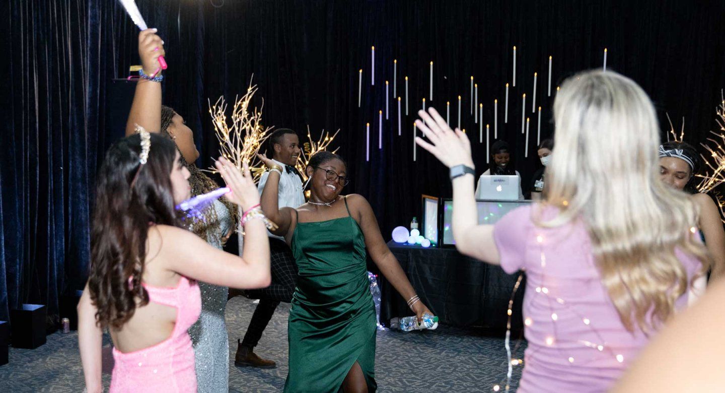 A group of teenagers in prom dresses dance at the U C S F Benioff Children's Hospital Oakland prom night event.