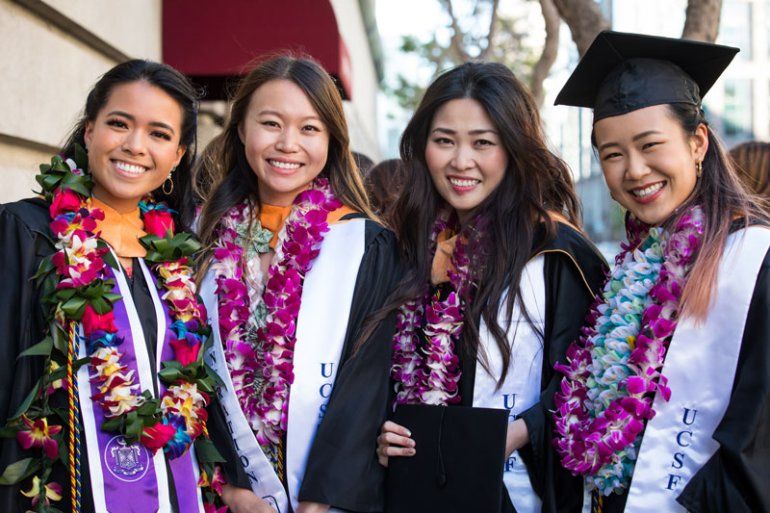 School of Nursing graduates pose for a photo wearing tropical flower leis