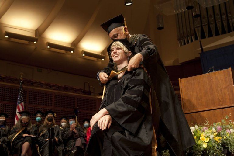 A School of Pharmacy student is hooded by the Dean of Pharmacy at the 2022 School of Pharmacy commencement ceremony