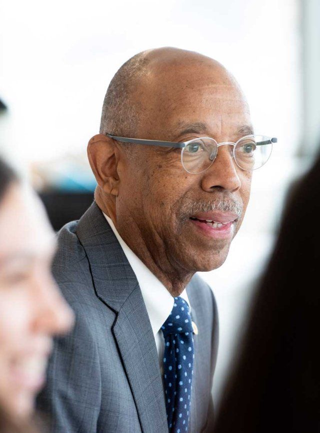 Michael Drake speaks with medical students in a light-filled room.