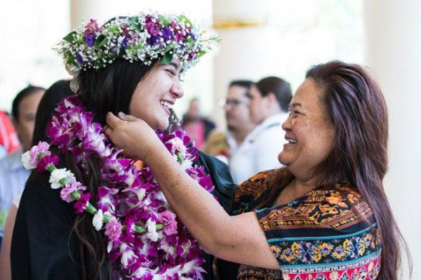 woman gives student a lei