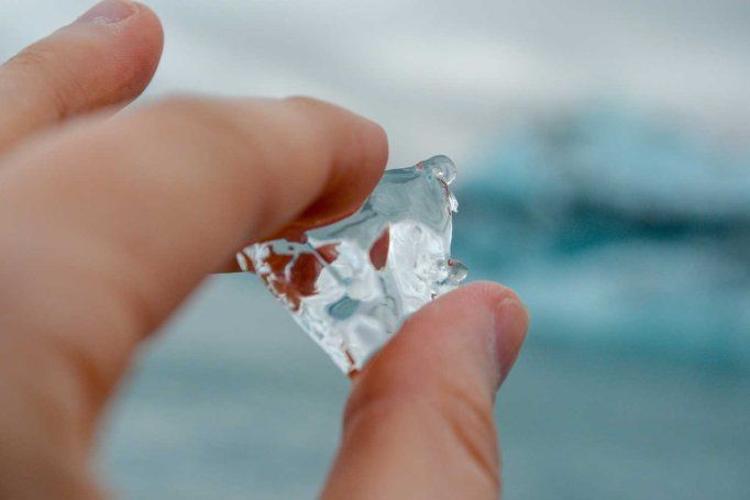 A hand holds a shard of ice.