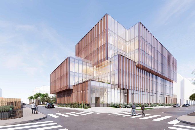Rendering of the U C S F Bakar Ear and Hearing Institute, a contemporary research building with stacked, offset volumes and a glass curtain wall wrapped in vertical copper-toned fins, situated on a sunny urban corner in Mission Bay with crosswalks, cars, and pedestrians.