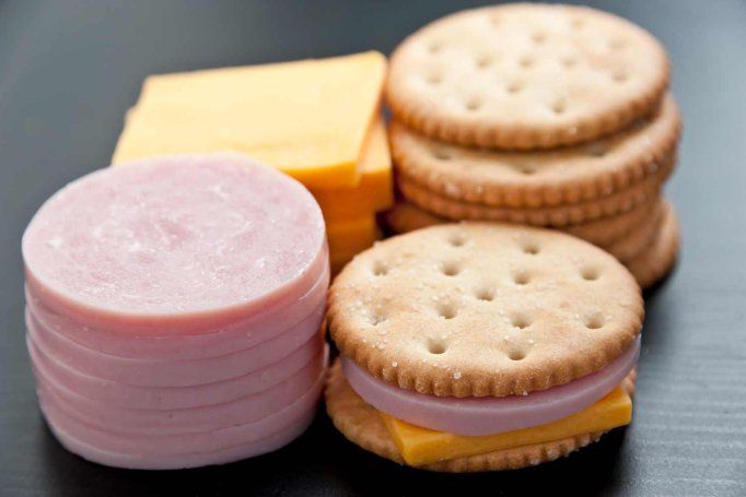 An arrangement of ultra processed food for children, including lunch meats, cheese, and crackers.