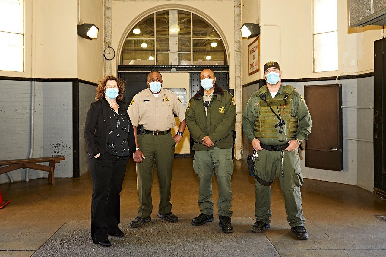 Photo of Brie Williams and correctional officers at San Quentin State Prison.