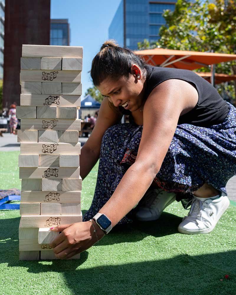 UCSF staff member Anya Gunewardena  carefully slides a wood block from the Jenga puzzle hoping the tower stays intact.
