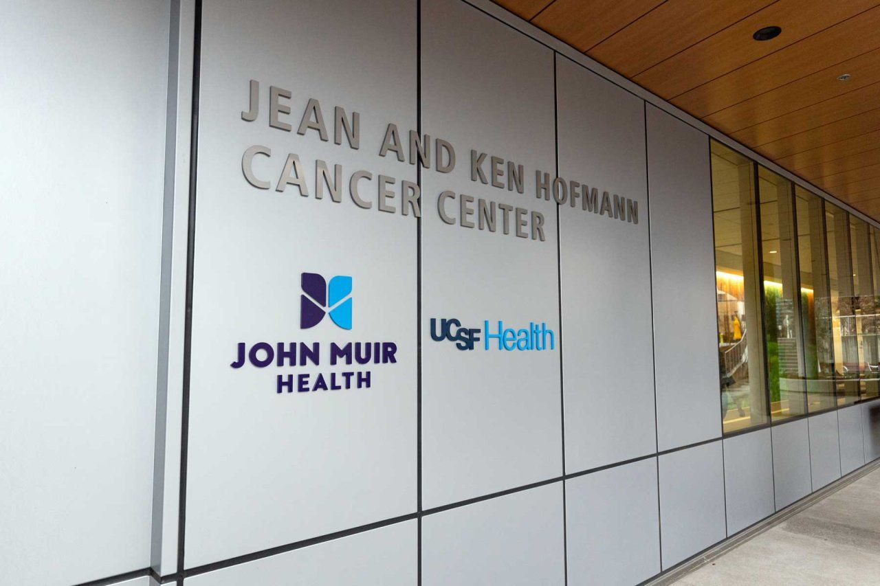 A wall with signage that reads Jean and Ken Hoffman Cancer Center, with logos for John Muir Health and UCSF Health.