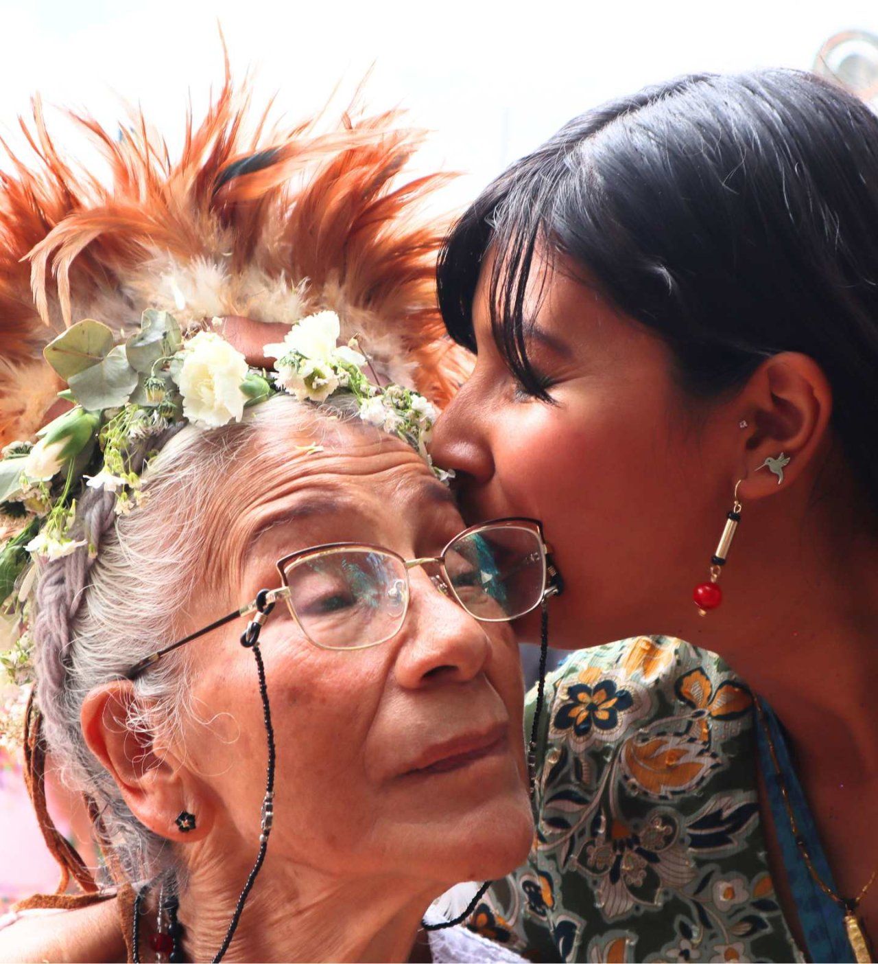 Elderly woman with flowers in hair receives a kiss by Fullbright scholar