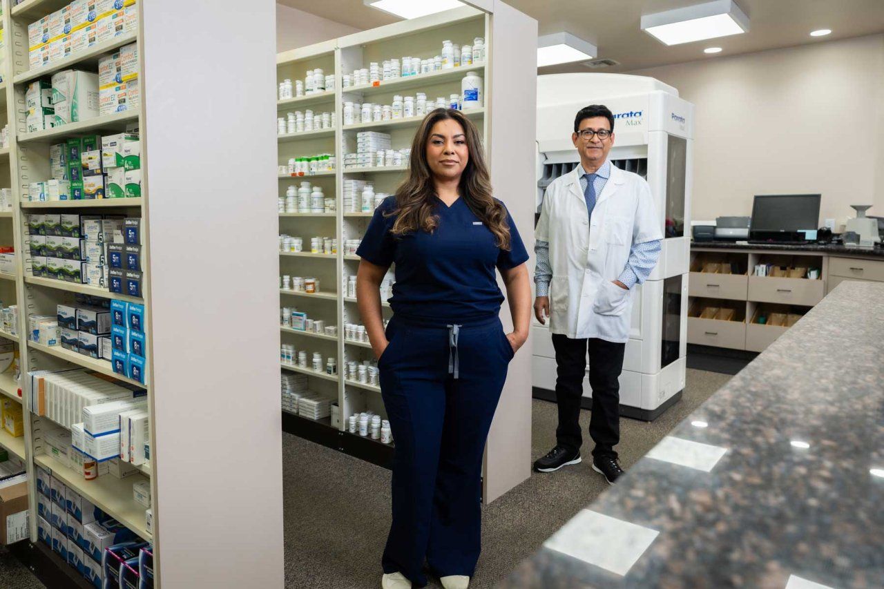 Pharmacy technician Bibiana Arroyo and a pharmacist colleague stand together at a pharmacy.