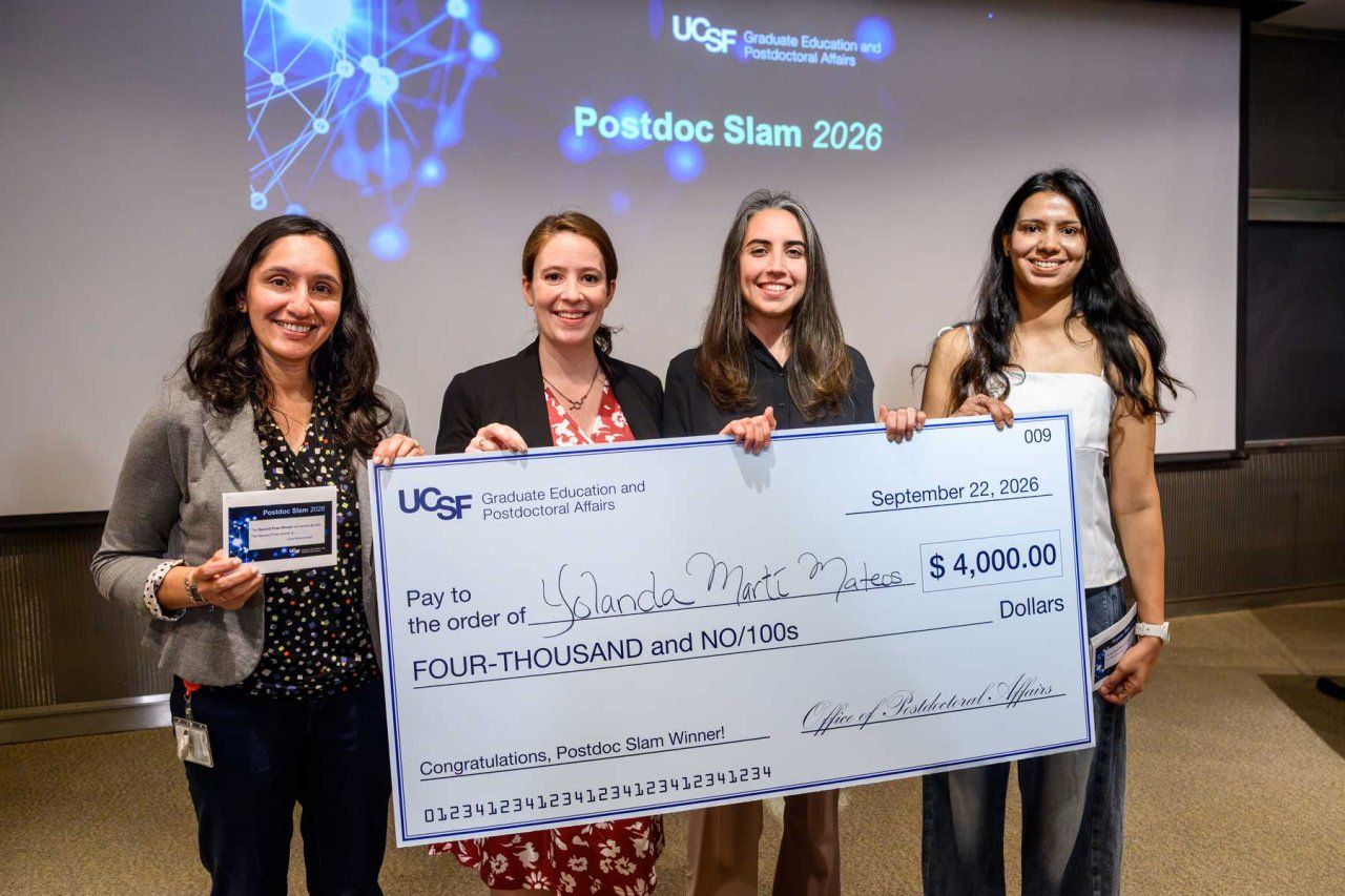 The first, second, and third place winners, along with the People's Choice Award winner, hold their prizes up on stage.