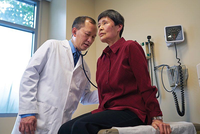Dr. Nguyen listens to the lungs of a patient