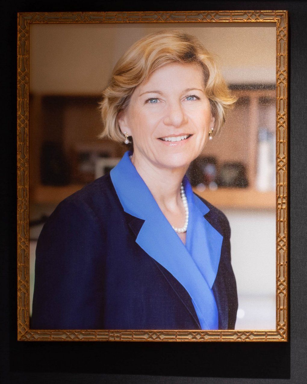 Susan Desmond-Hellmann smiles in an office in her official chancellor's portrait