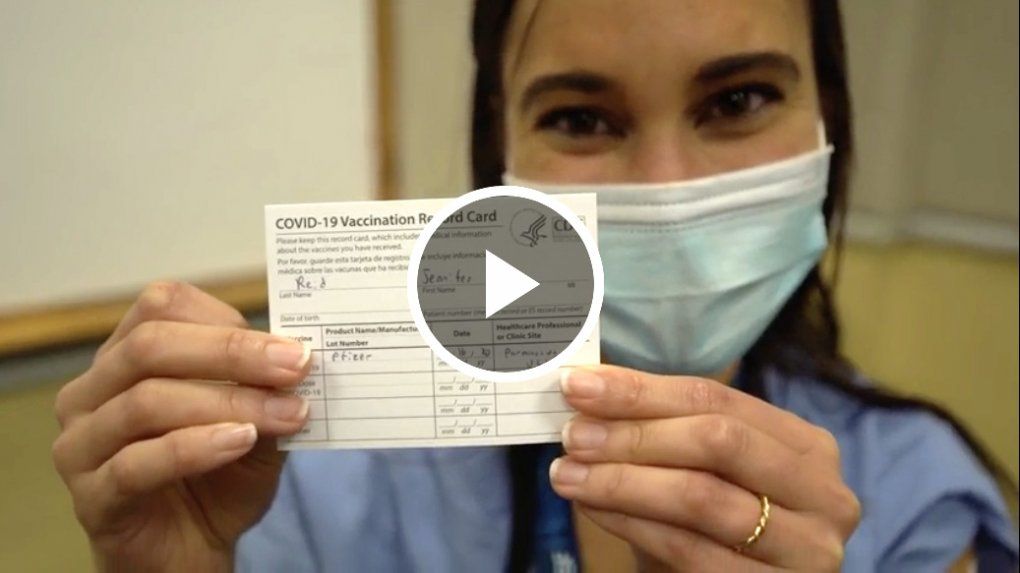 Patient who received a vaccination holding up a card