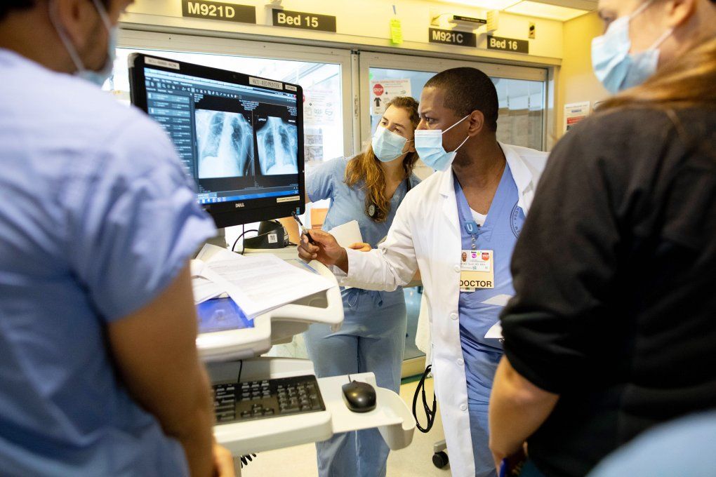 medical staff look at a respiratory image on a screen in the ICU 