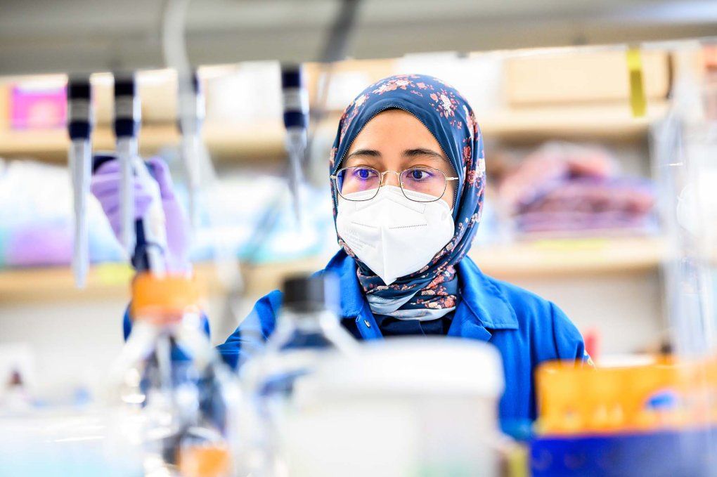 Shabrina Amirruddin sits at a lab bench pipetting