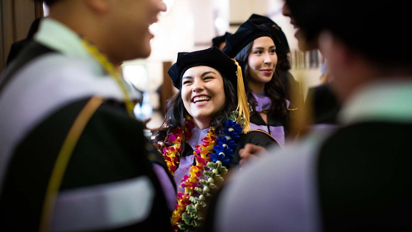 A student laughs outside of her commencement ceremony