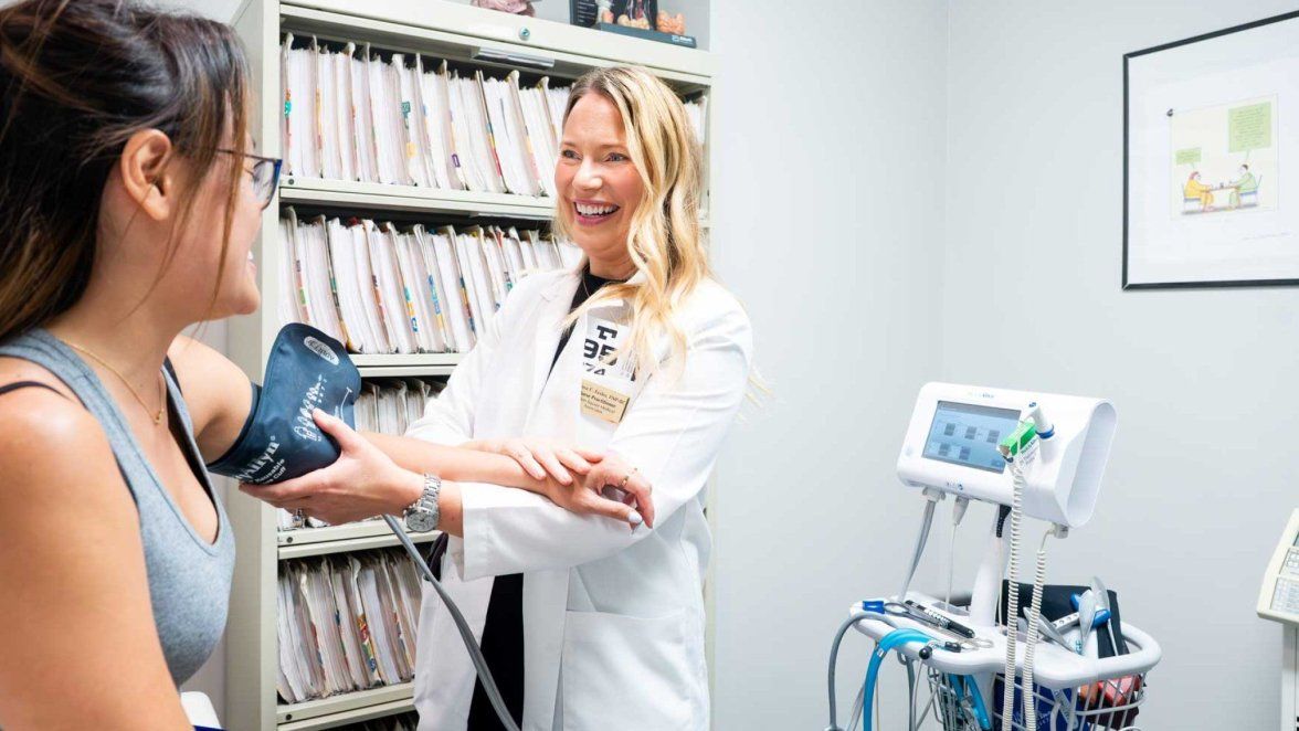 A woman gets her pressure checked in a doctor's office.