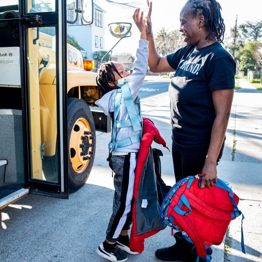 Rashetta Higgins high fives her youngest son outside of his schoolbus