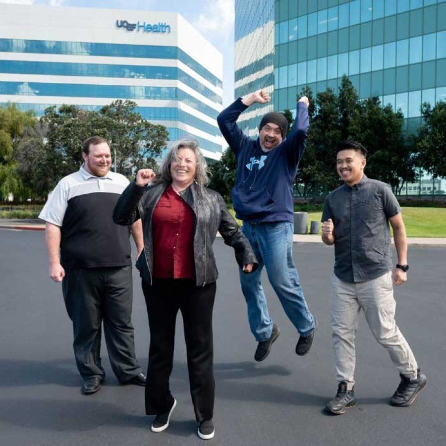 A group of U C S F I T staff member jump together in a photo.