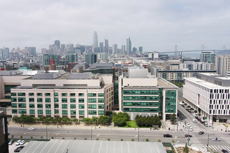 Aerial view of Mission Bay campus with San Francisco and the Bay Bridge in the distance