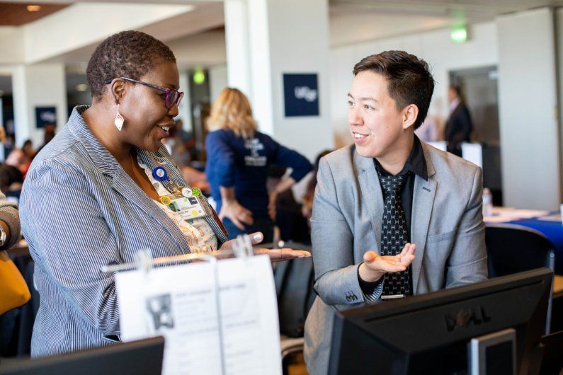 two women speak at a professional development booth
