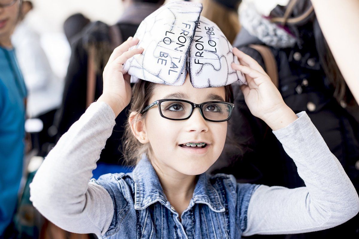 Elisa van Mechelen, 10, puts on hat she made, it depicts a human brain 