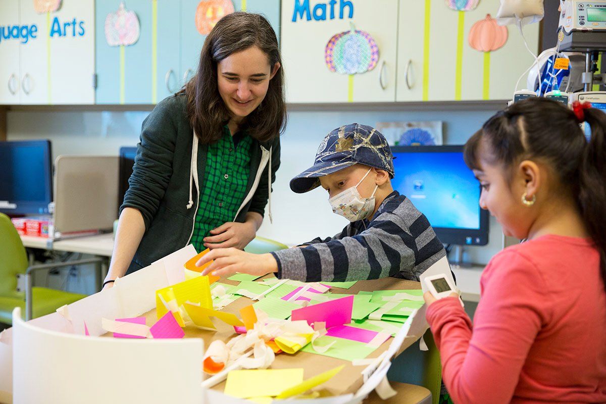 UCSF graduate student Isabelle Taylor leads an experiment with two children at the Bay Area Science Festival