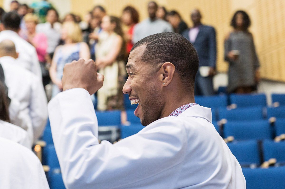 New School of Dentistry student Rubin Sorrell raises his hand in celebration during the school’s white coat ceremony