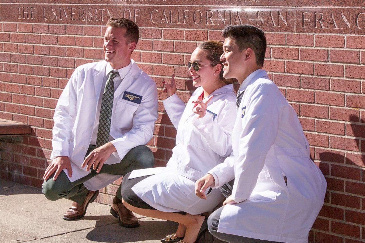 School of Dentistry students Tanner Olson, Francisca Forer and William Lee pose for a photo in their new white coats