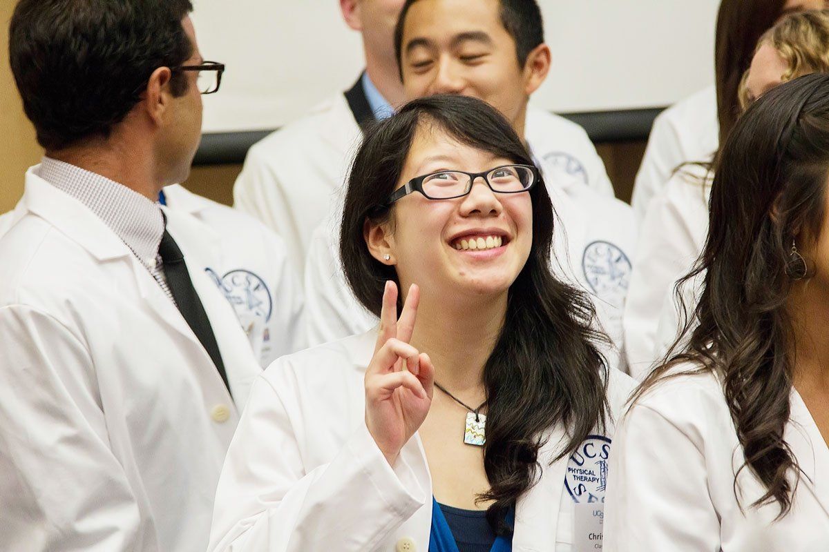 Student gives peace sign at her family