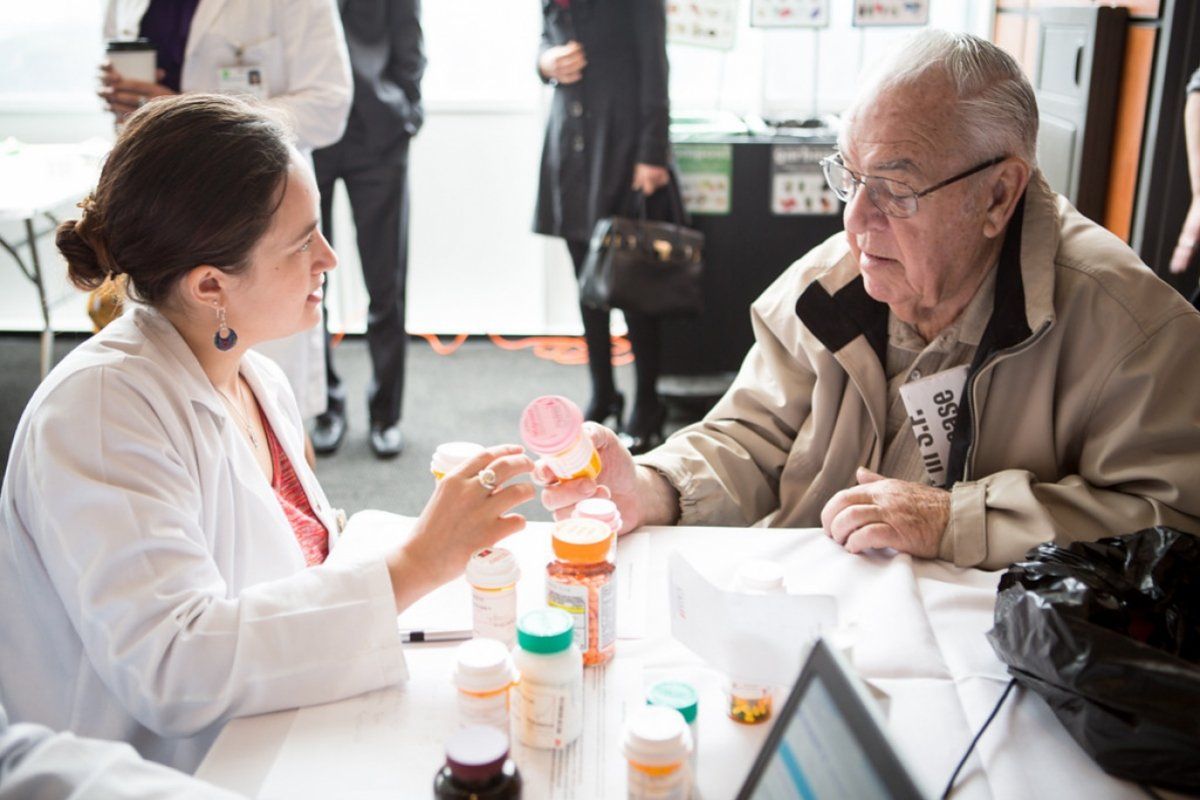 Patient receiving pills from pharmacist 