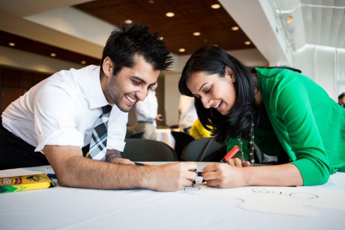 Two people drawing on poster board