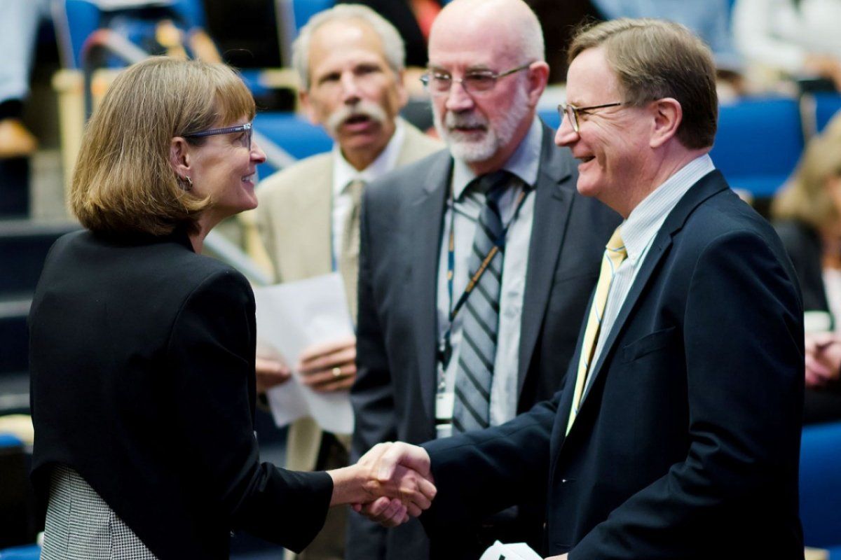 Sam Hawgood shaking hands with woman