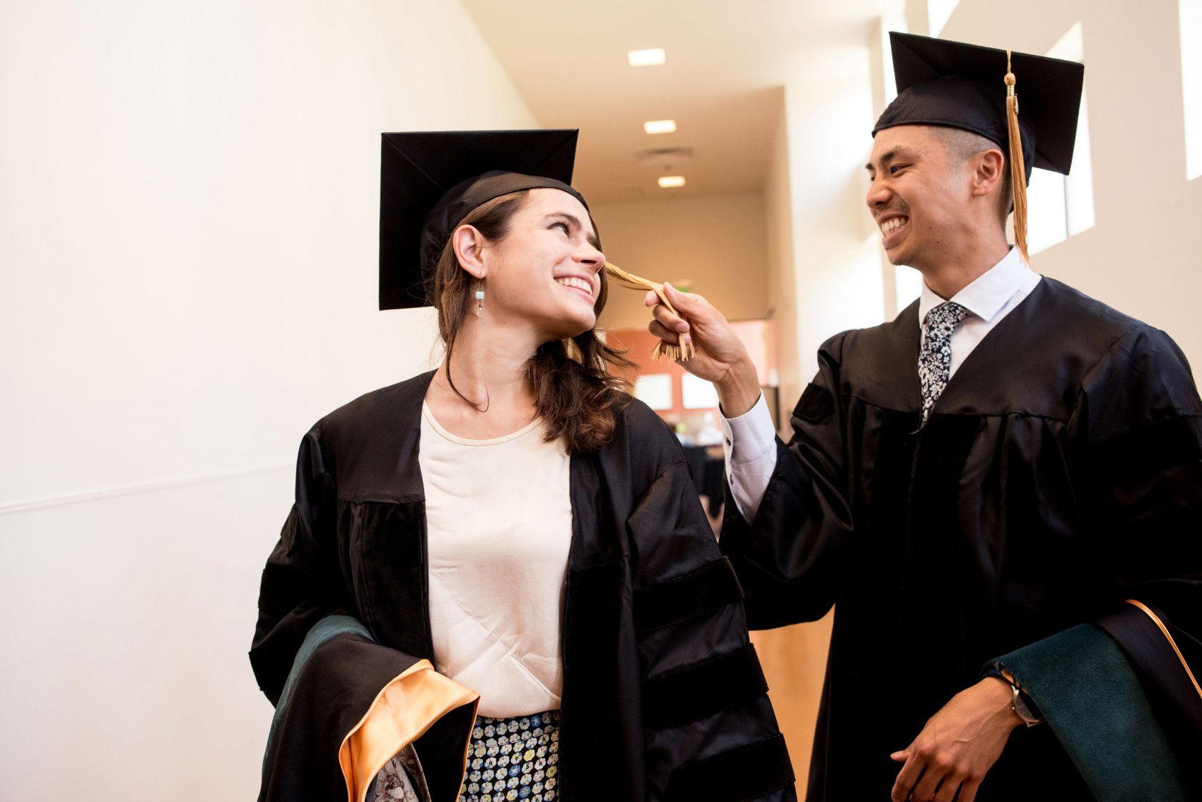Two students joking before commencement ceremony