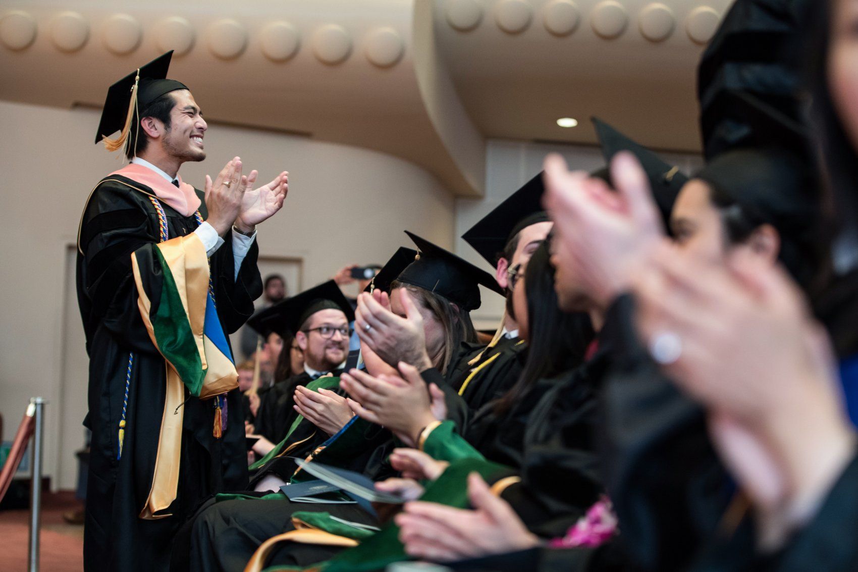 New Latthivongskorn stands and claps at SOM Commencement 2019