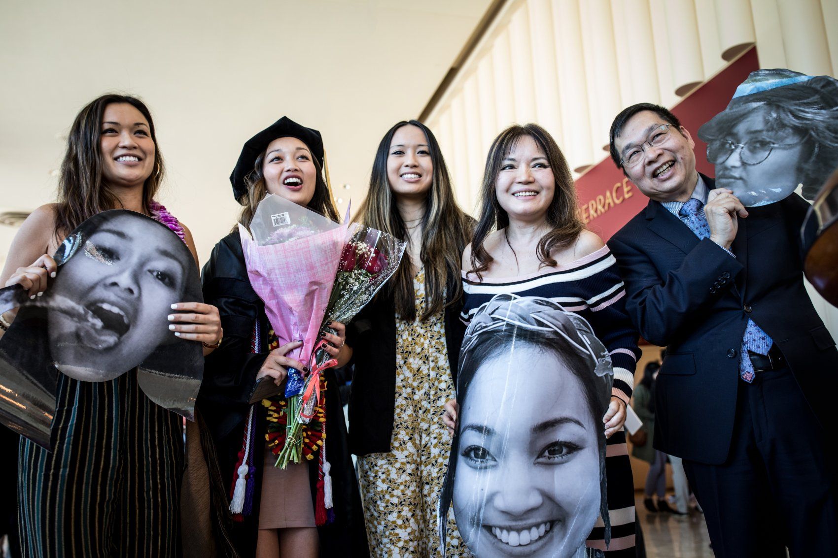 Grace Le's family holds photos of her at SOP Commencement 2019